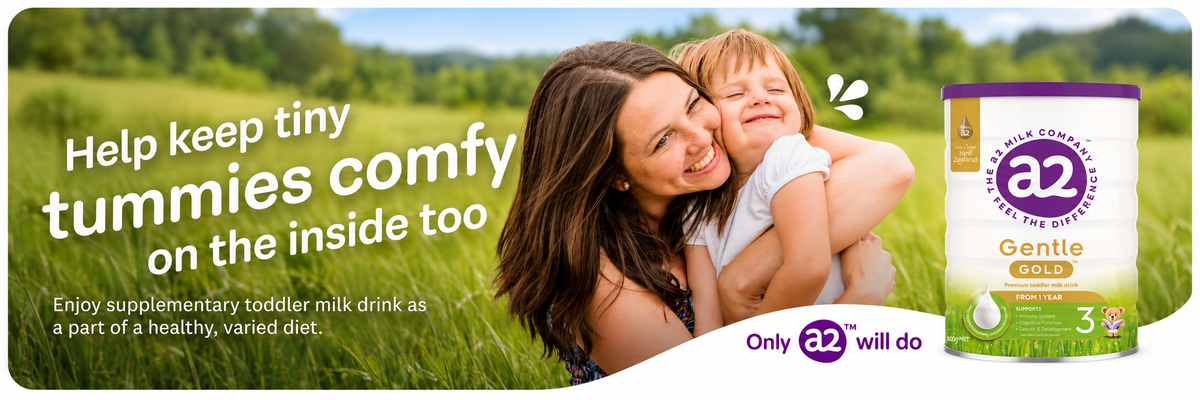 Mum and toddler hugging in a grassy field with a2 Gentle Gold Stage 3 toddler milk drink